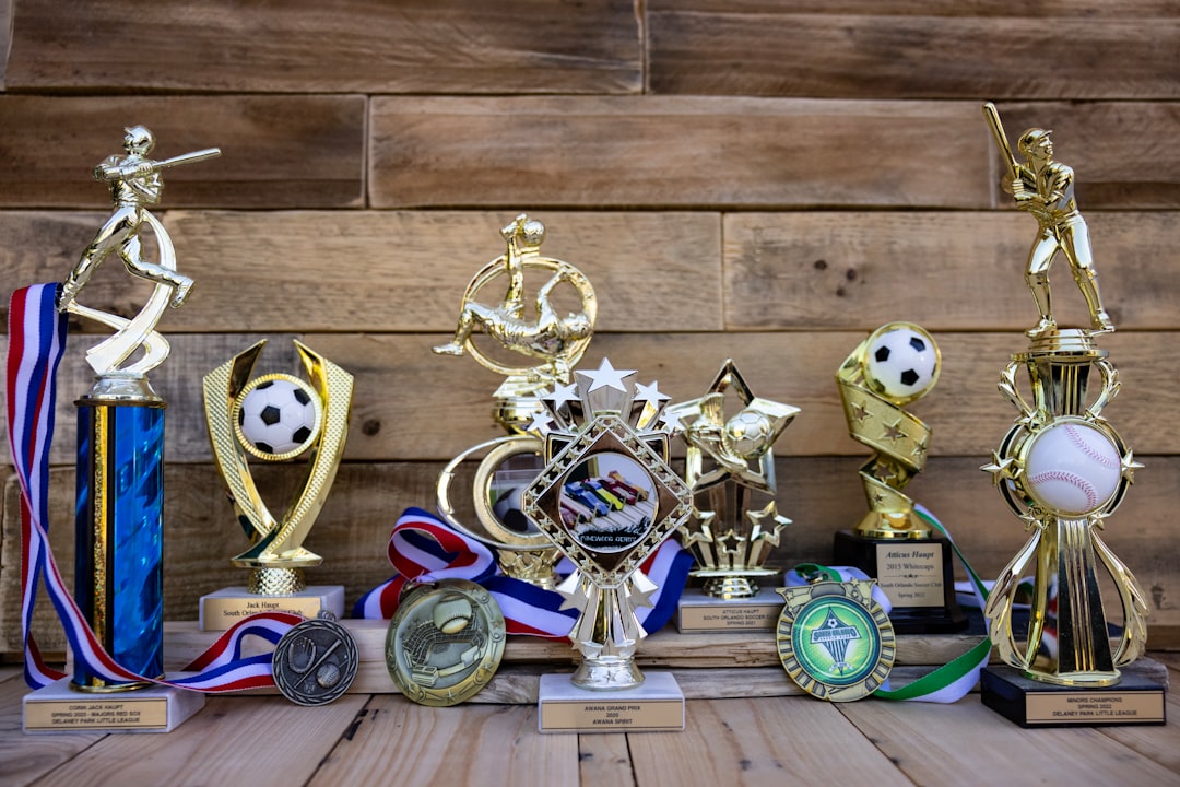 Collection of sports trophies and medals on wooden background