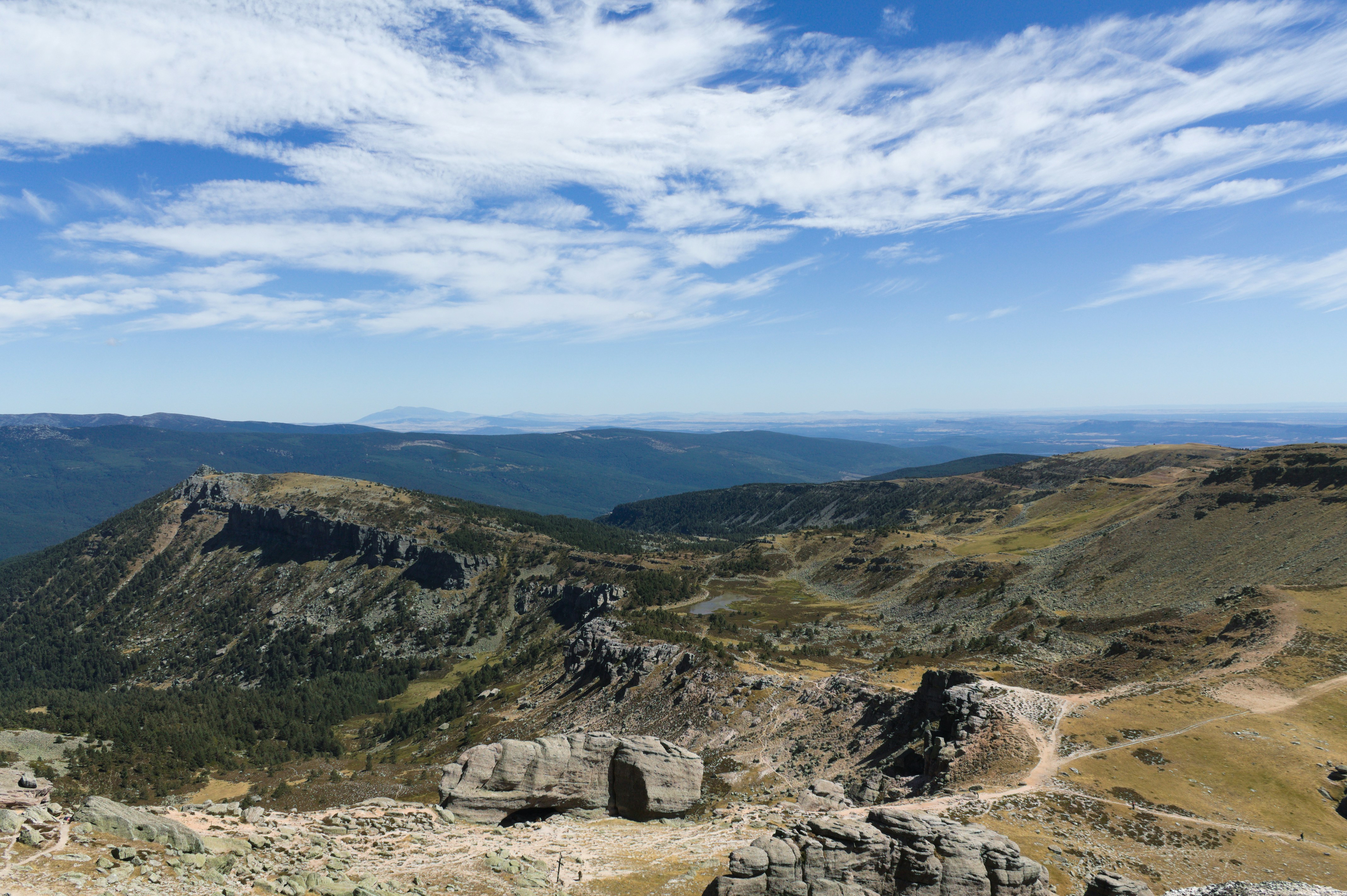 Paisaje de montañas rocosas con un cielo azul nublado