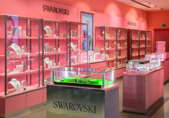 Swarovski store interior with pink walls and display cases.
