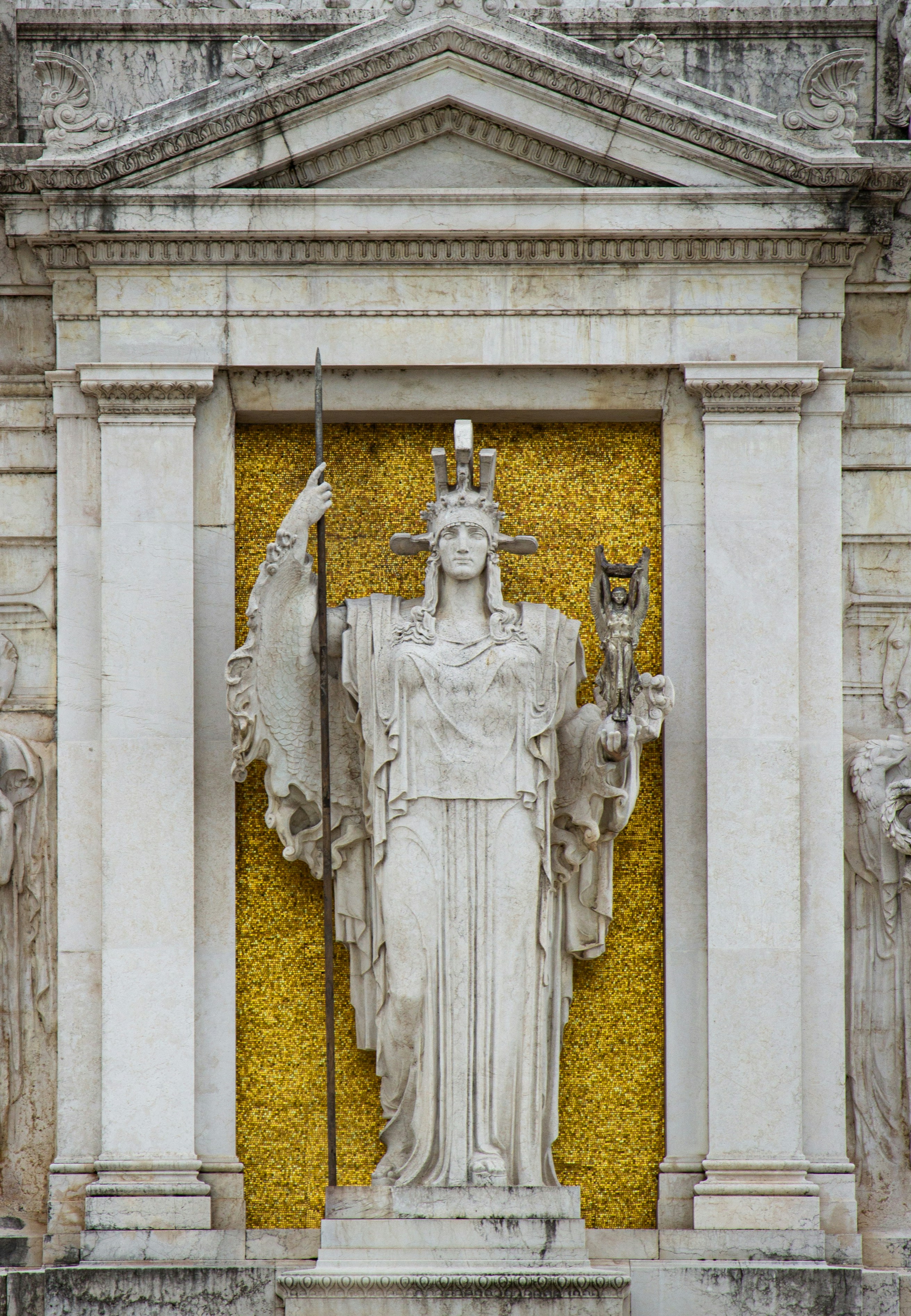 Marble statue of a robed woman holding a spear.