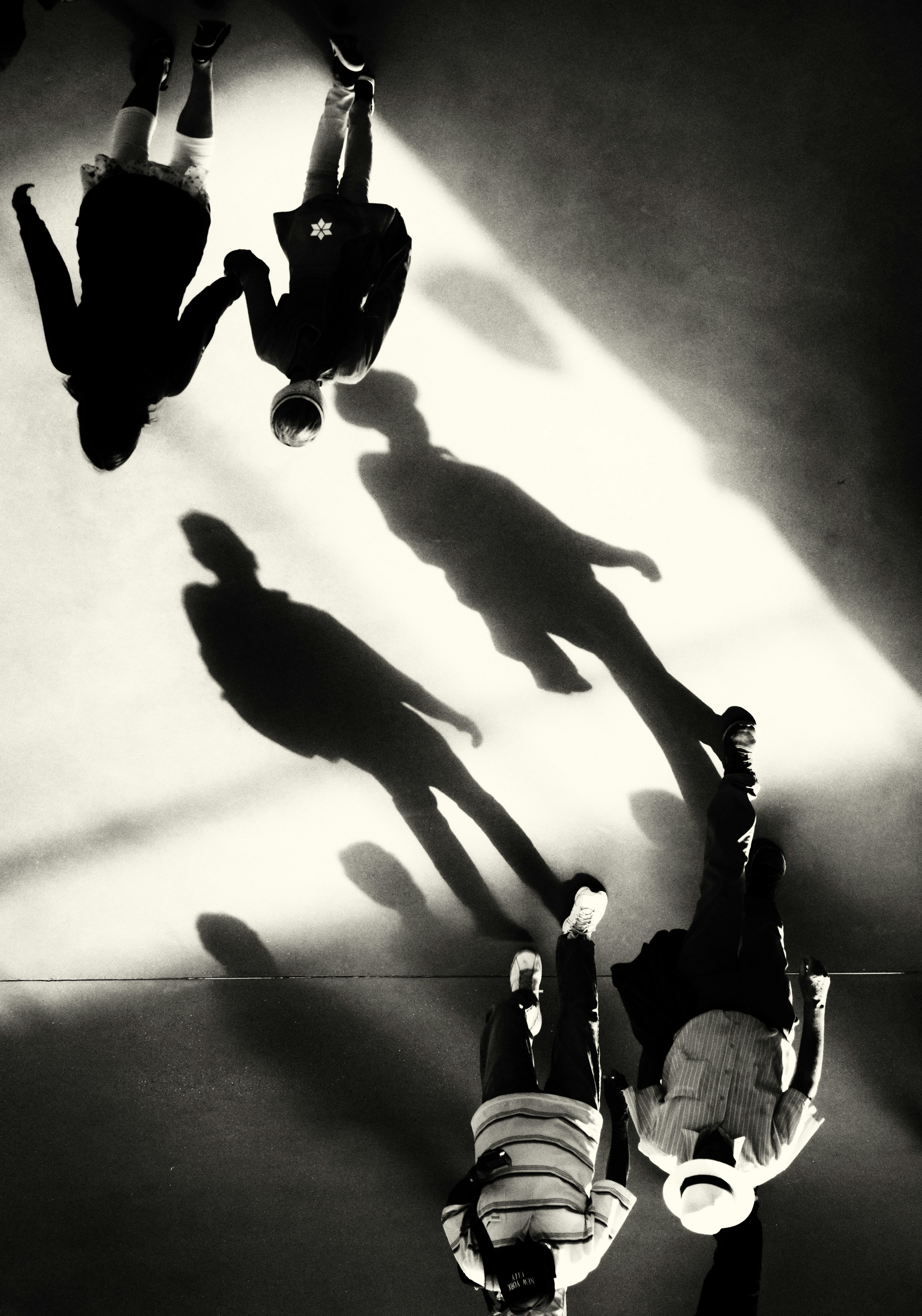 Silhouettes of people walking with long shadows