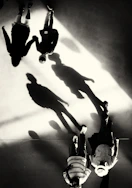 Silhouettes of people walking with long shadows
