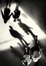 Silhouettes of people walking with long shadows