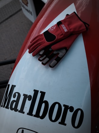 Red racing gloves resting on marlboro branded surface