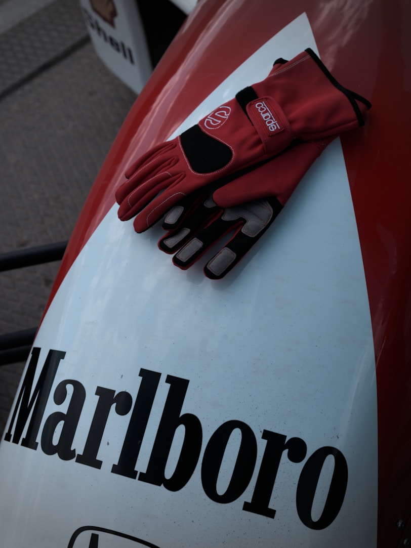 Red racing gloves resting on marlboro branded surface