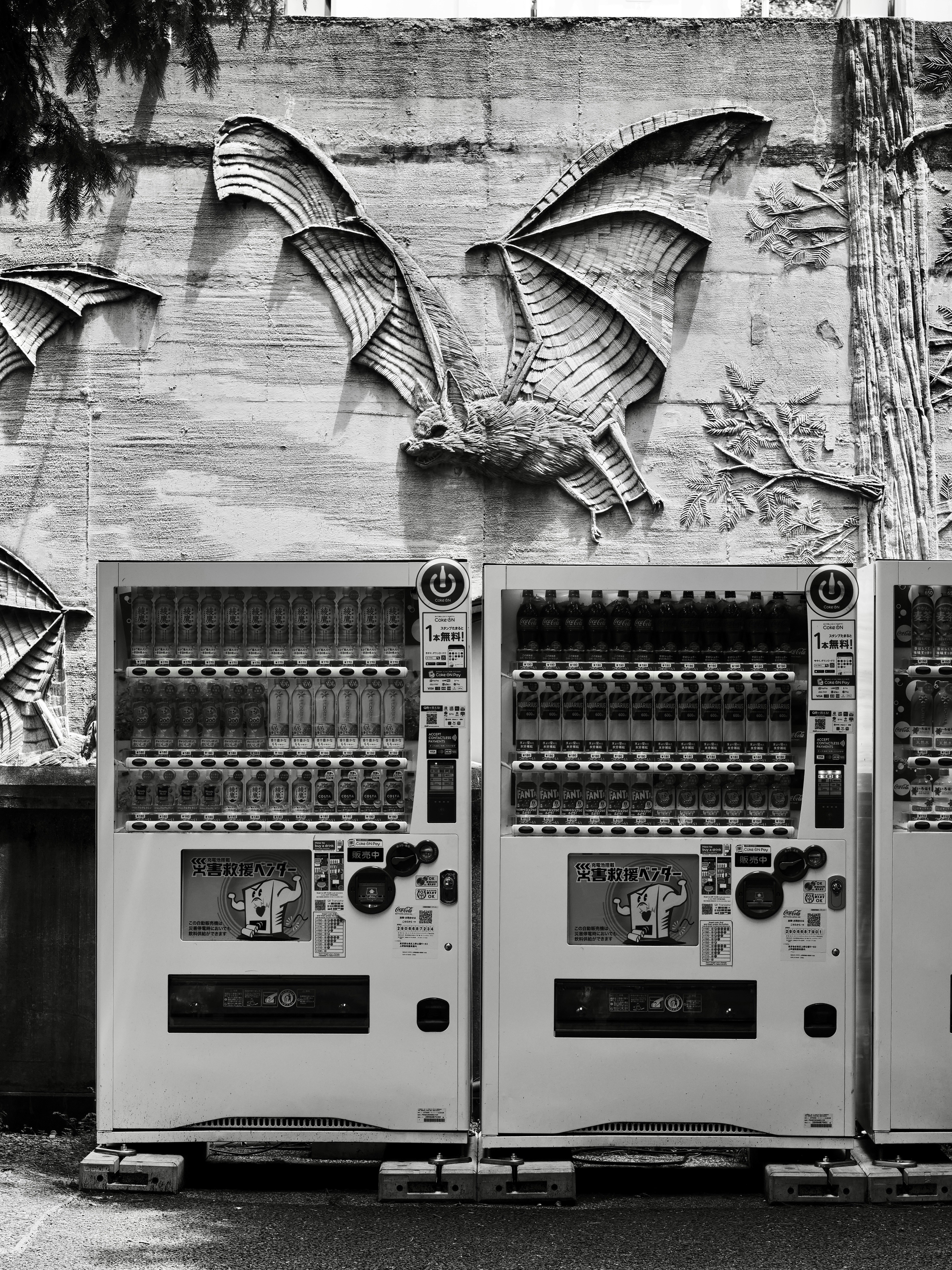 Vending machines with a relief of a bat on the wall behind it