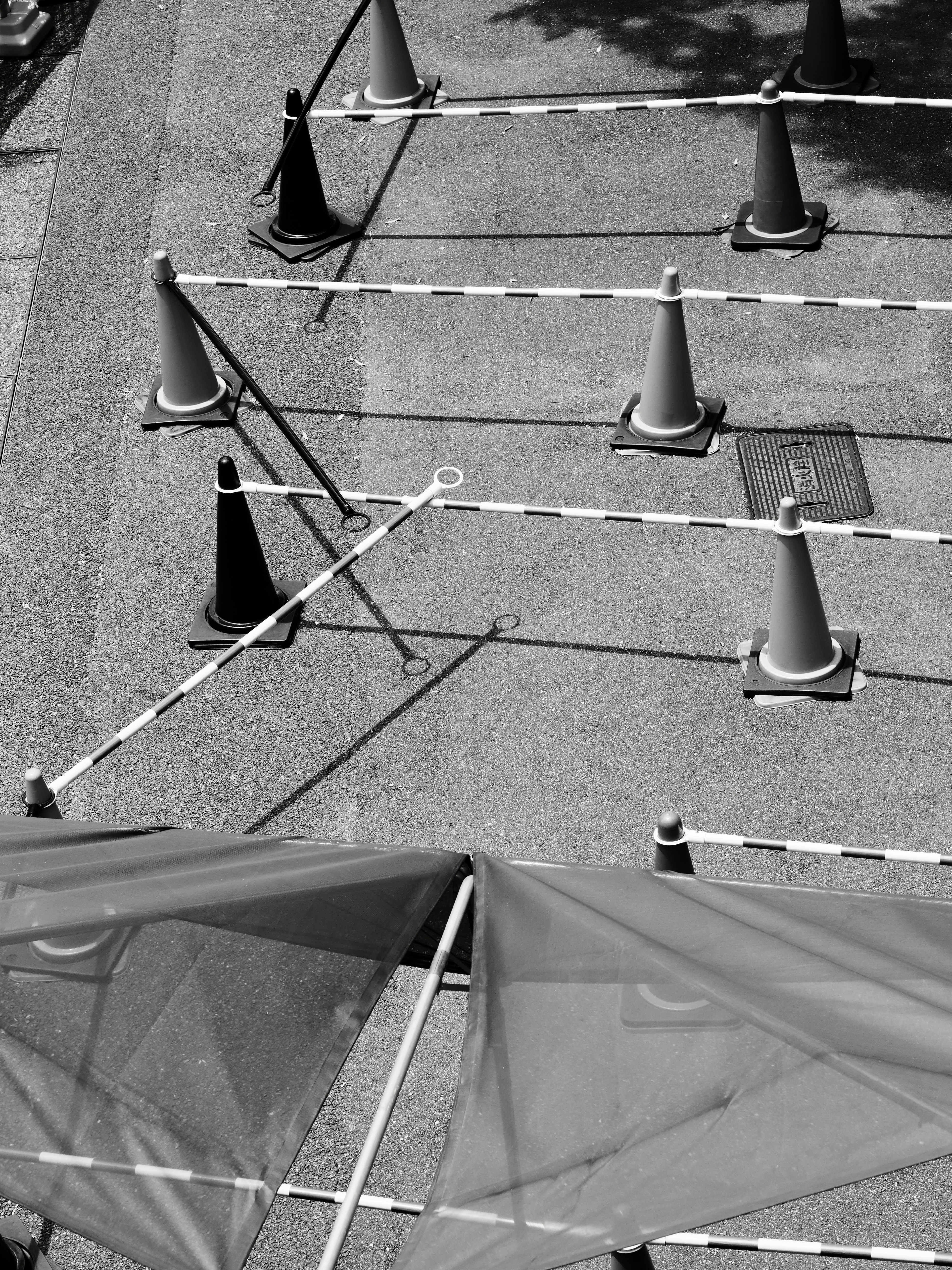 Conos de tráfico naranjas y negros con cinta de precaución.