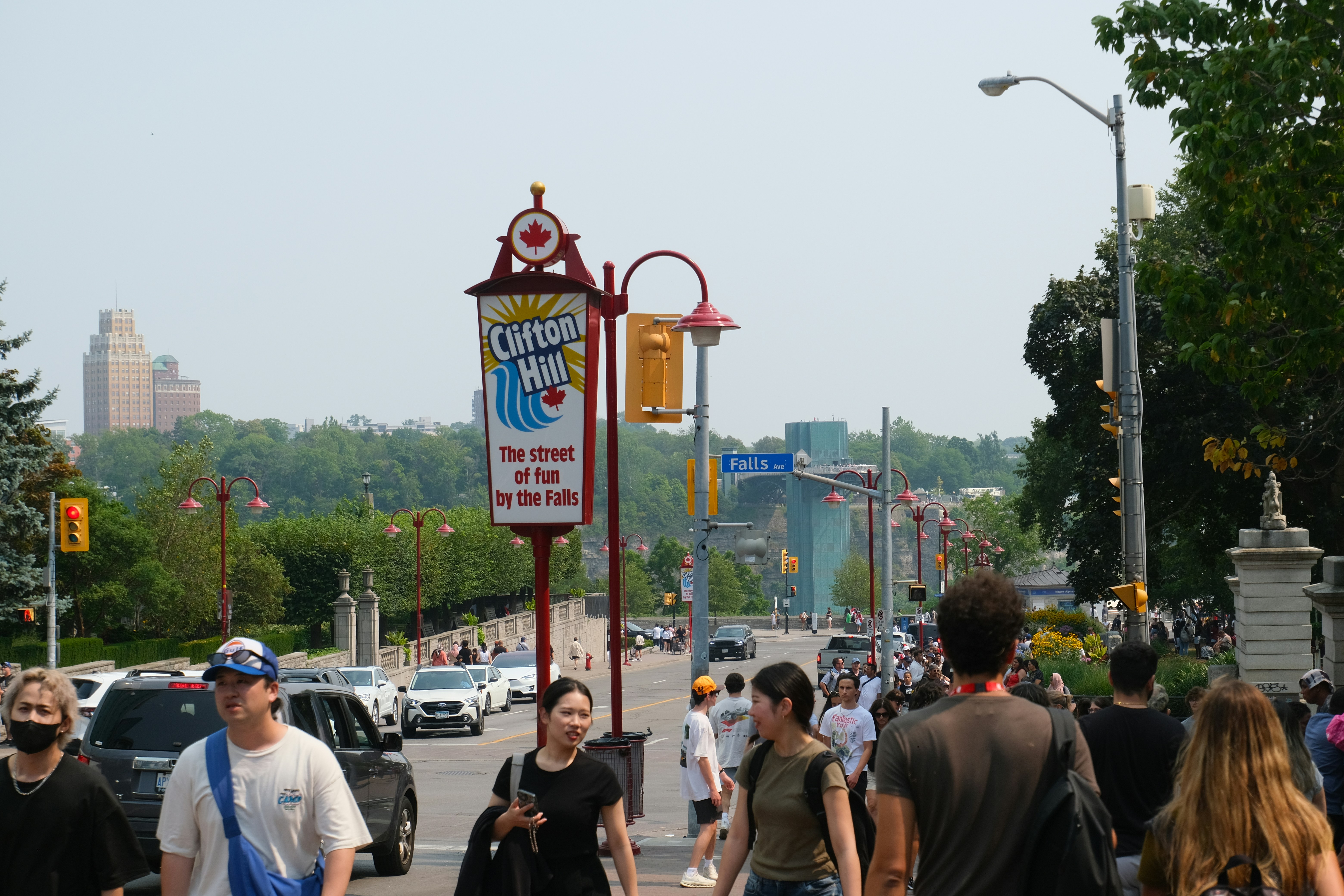 Multidão de pessoas andando perto de uma placa para clifton hill.