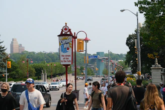 Crowd of people walking near a sign for clifton hill.