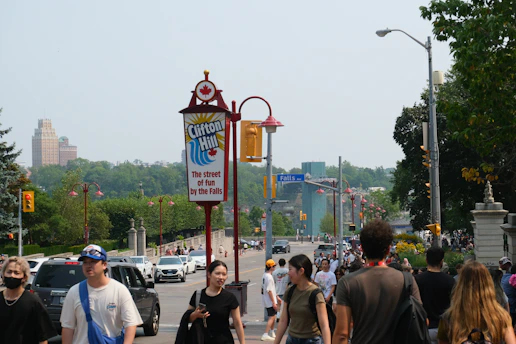 Crowd of people walking near a sign for clifton hill.