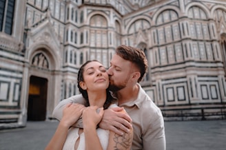 Couple embracing in front of a historic cathedral