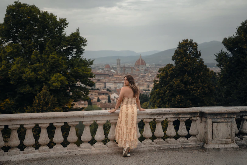 Woman overlooks florence cityscape from balcony