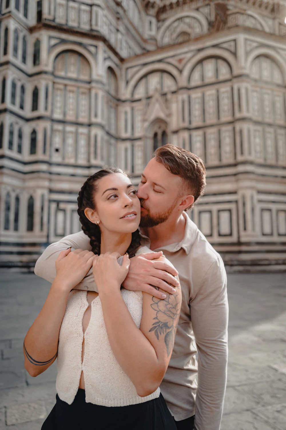 Sofia and James embracing in front of Florence Cathedral