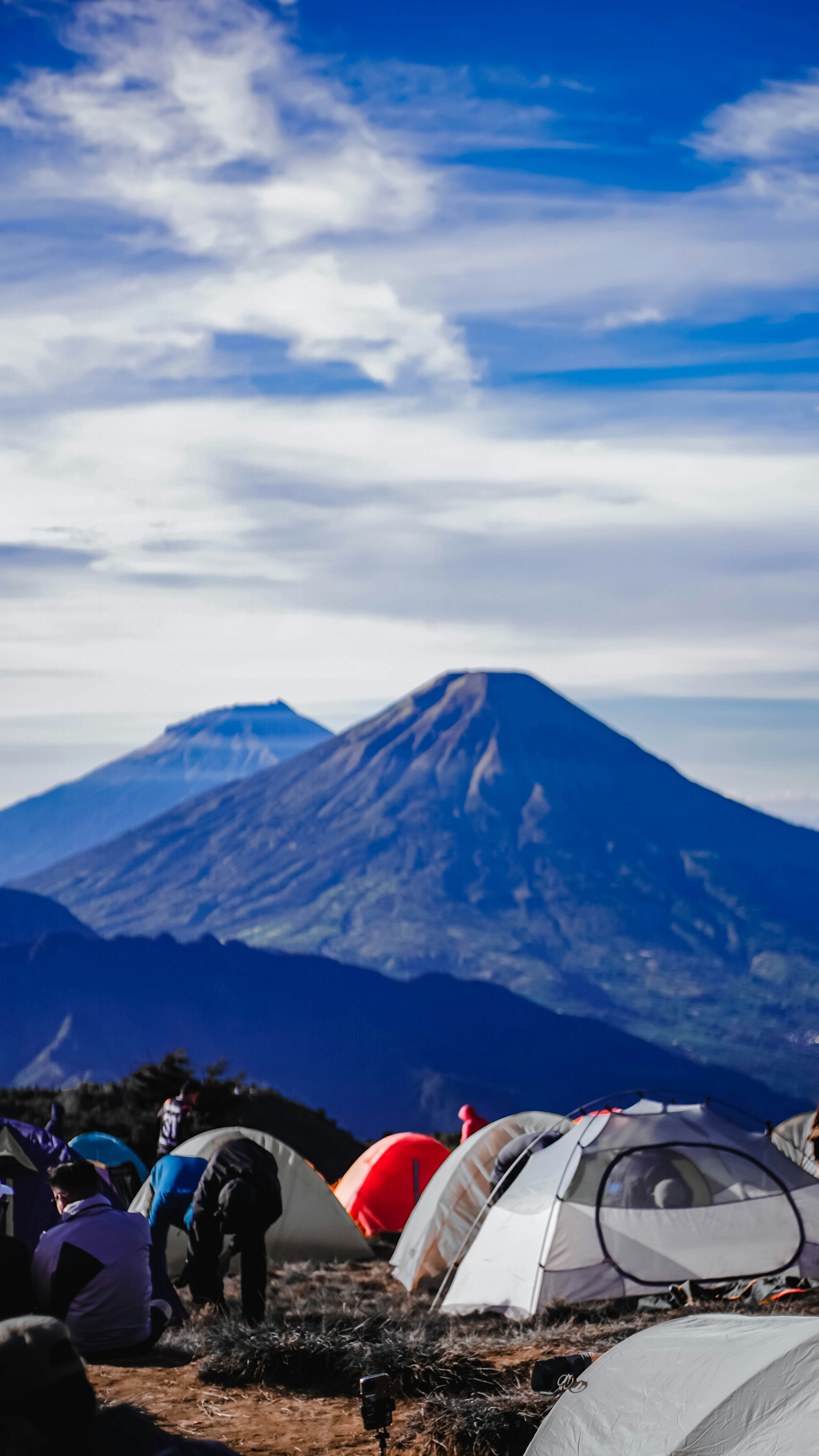 Campground with tents and mountains under blue sky