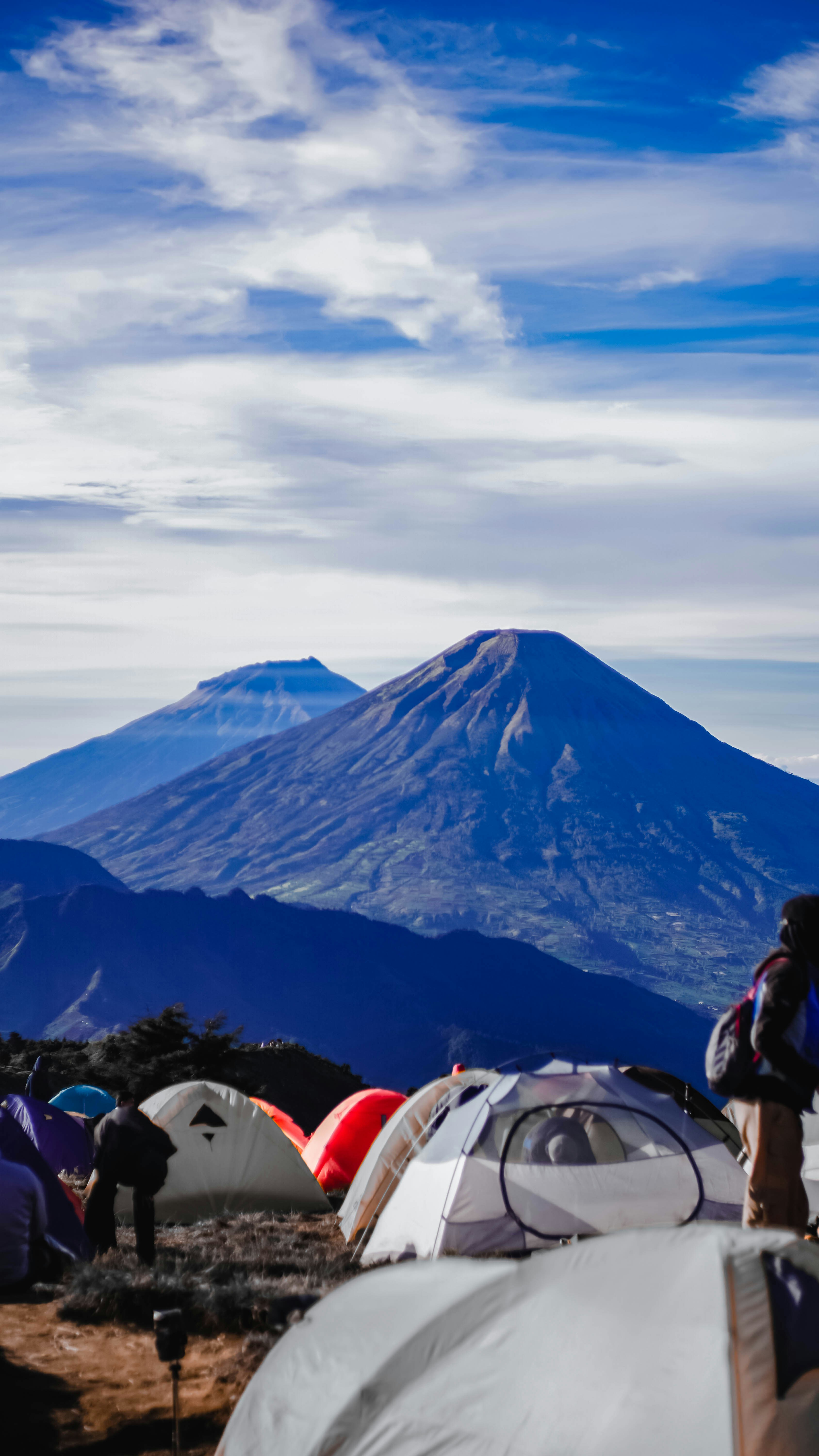 Tents set up on a mountain with majestic peaks behind.