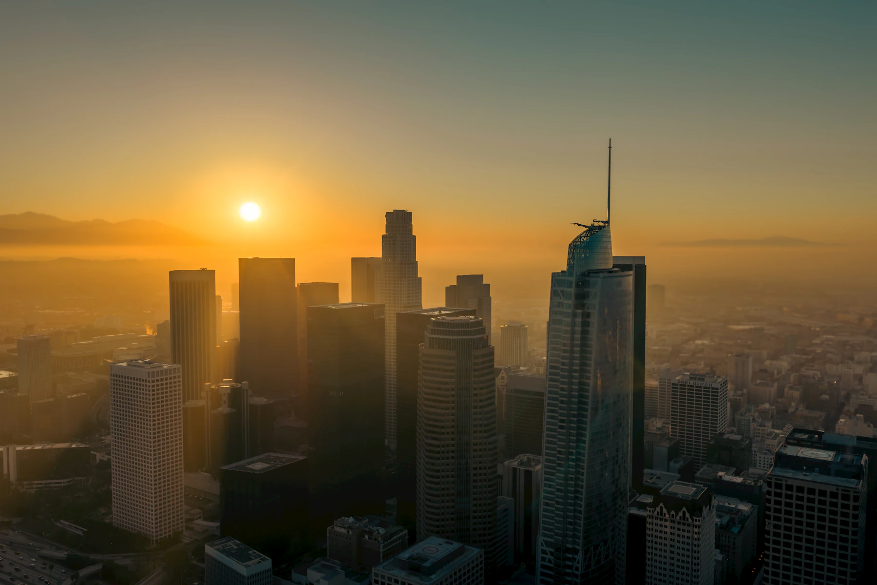 Downtown Los Angeles towers glowing in the warm light of sunrise