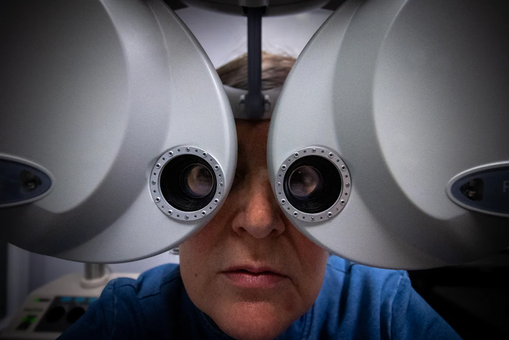 Patient undergoing vision testing on eye examination equipment during a routine check-up