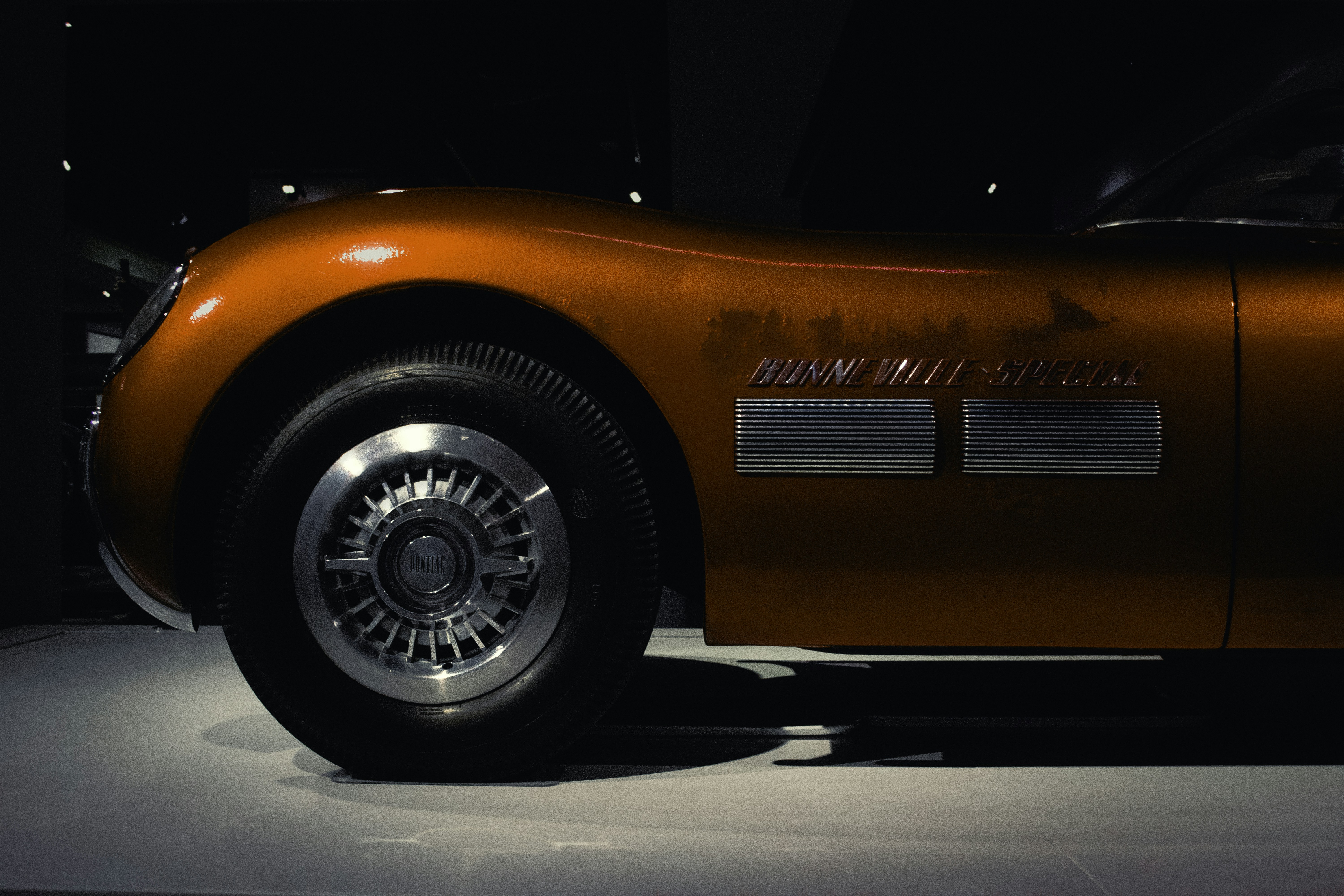 Close-up of an orange vintage car's fender.