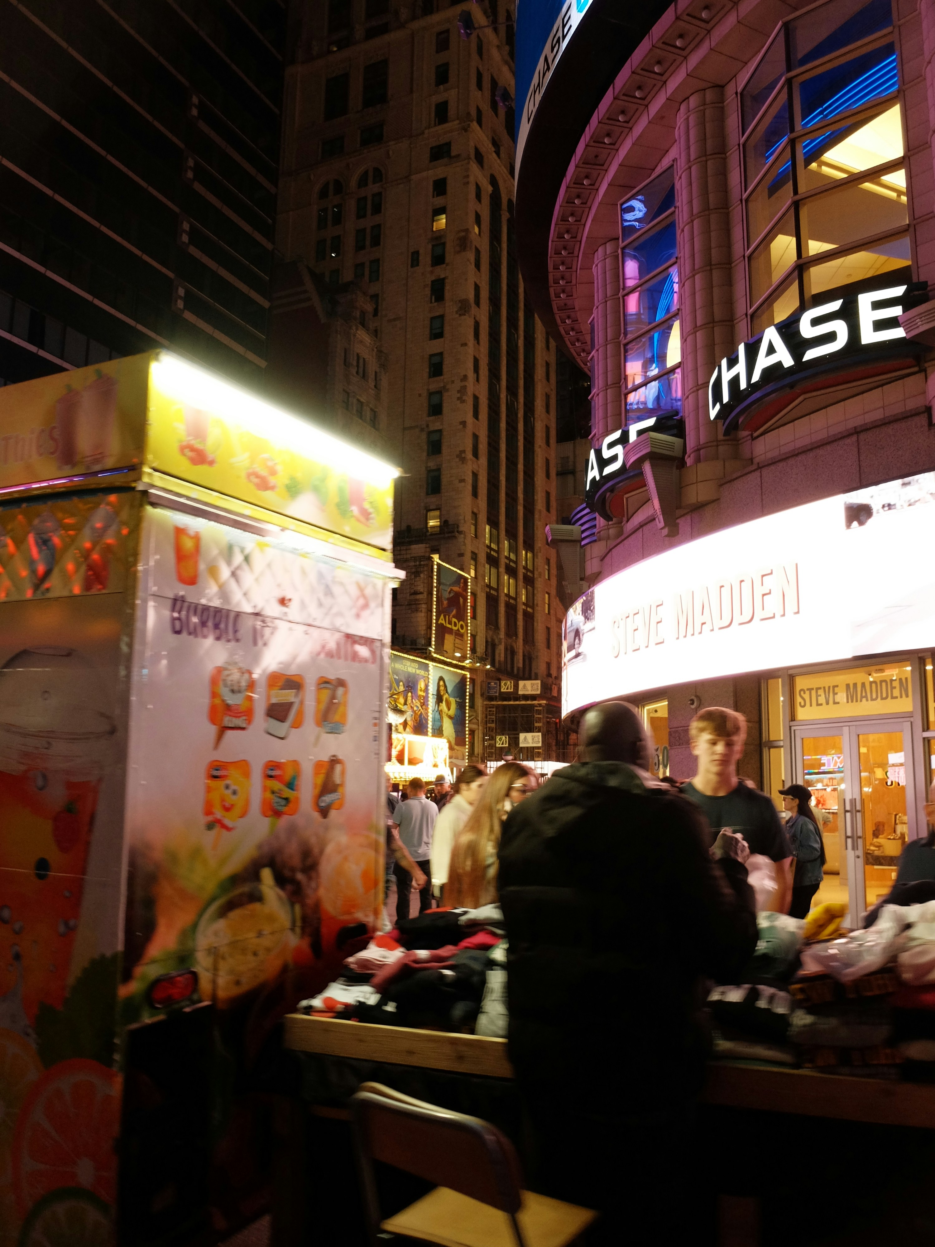 Street vendor selling goods in a bustling city at night