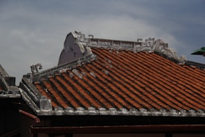 Traditional tiled roof with ornate detailing against sky