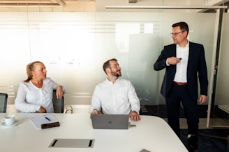 Three business people in a modern office meeting.
