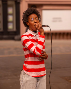 Young woman singing into a microphone outdoors