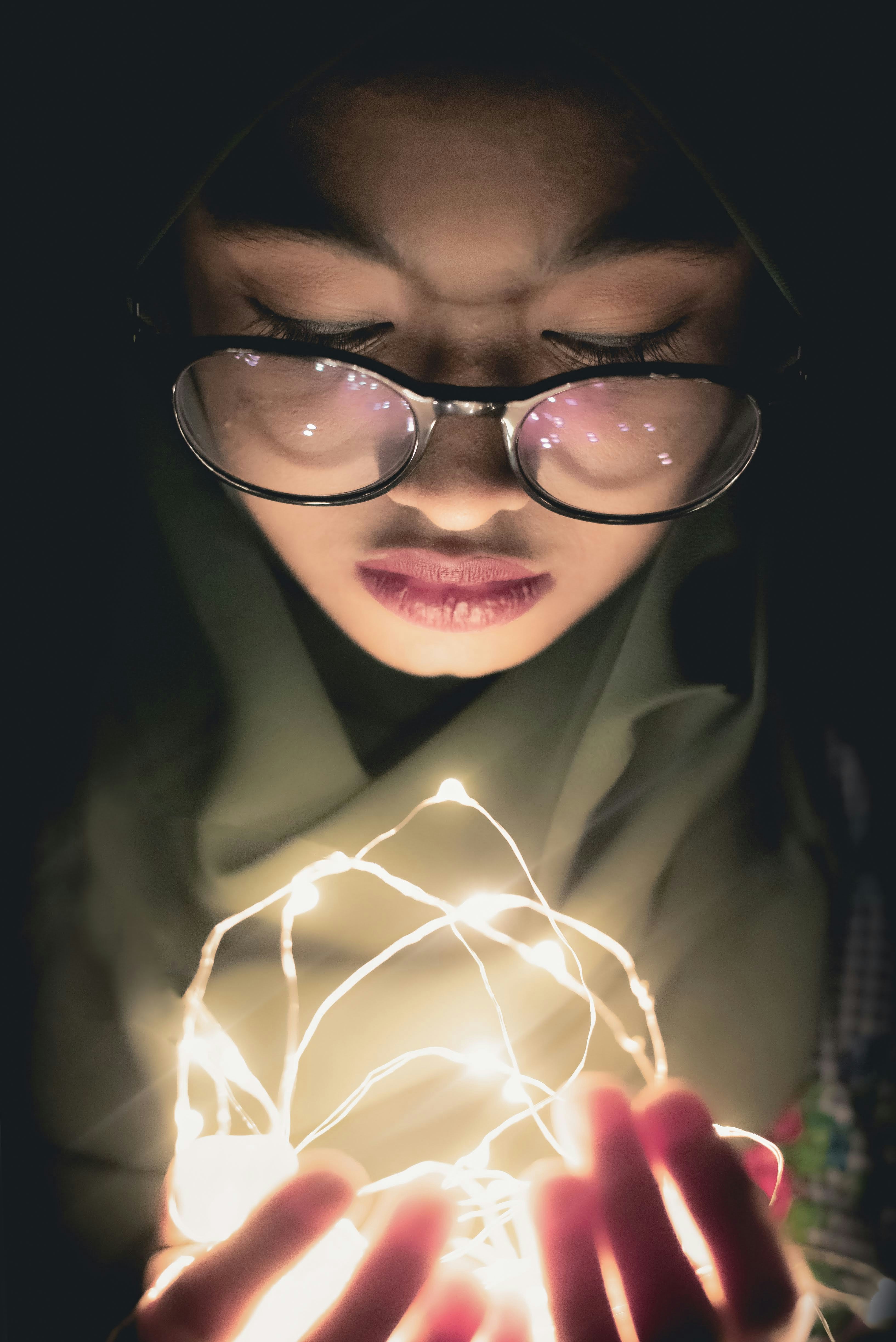 Young woman holding glowing fairy lights
