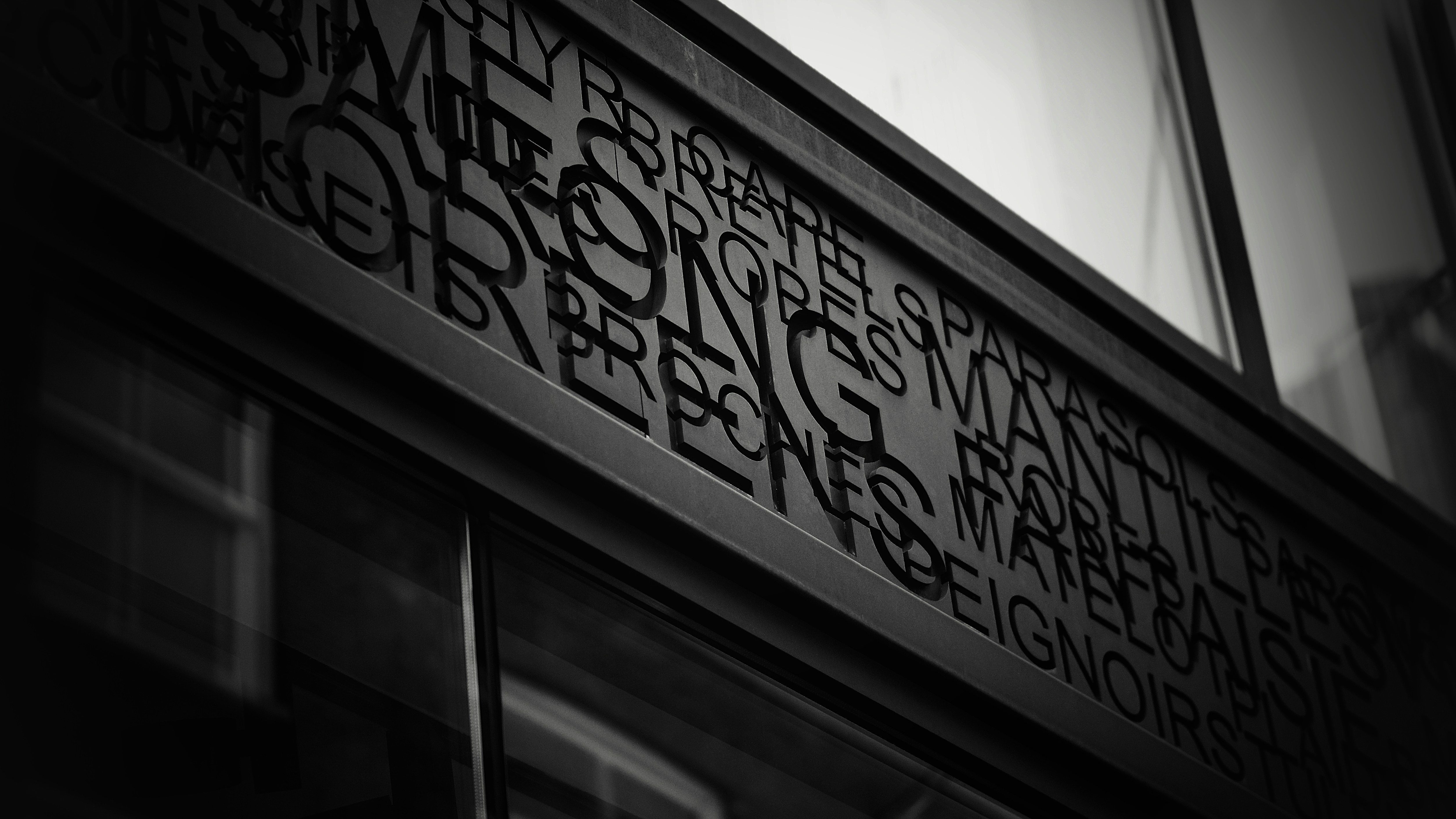 Text carved into a building facade at night.
