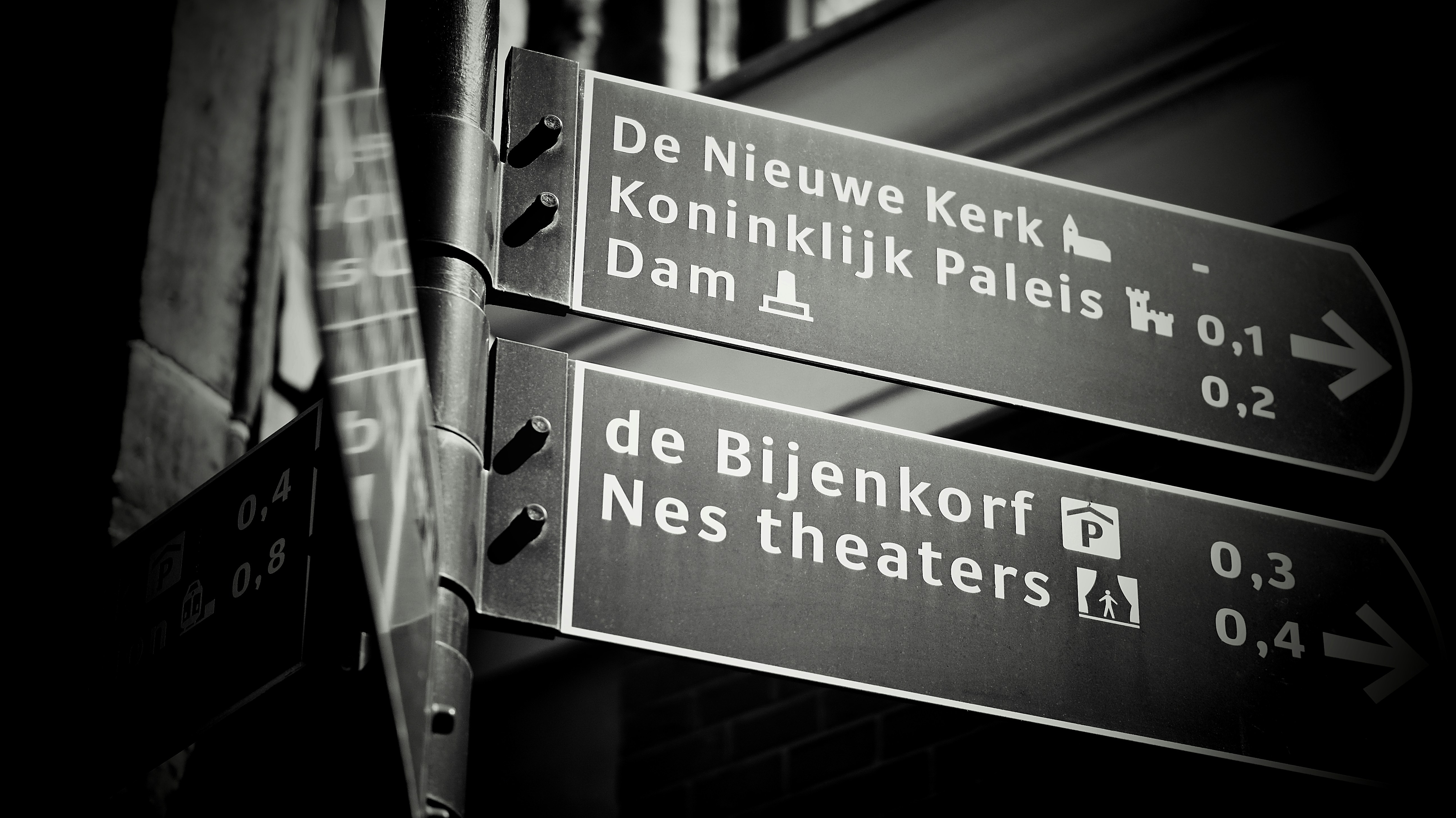 Street signs point towards de nieuwe kerk and dam.