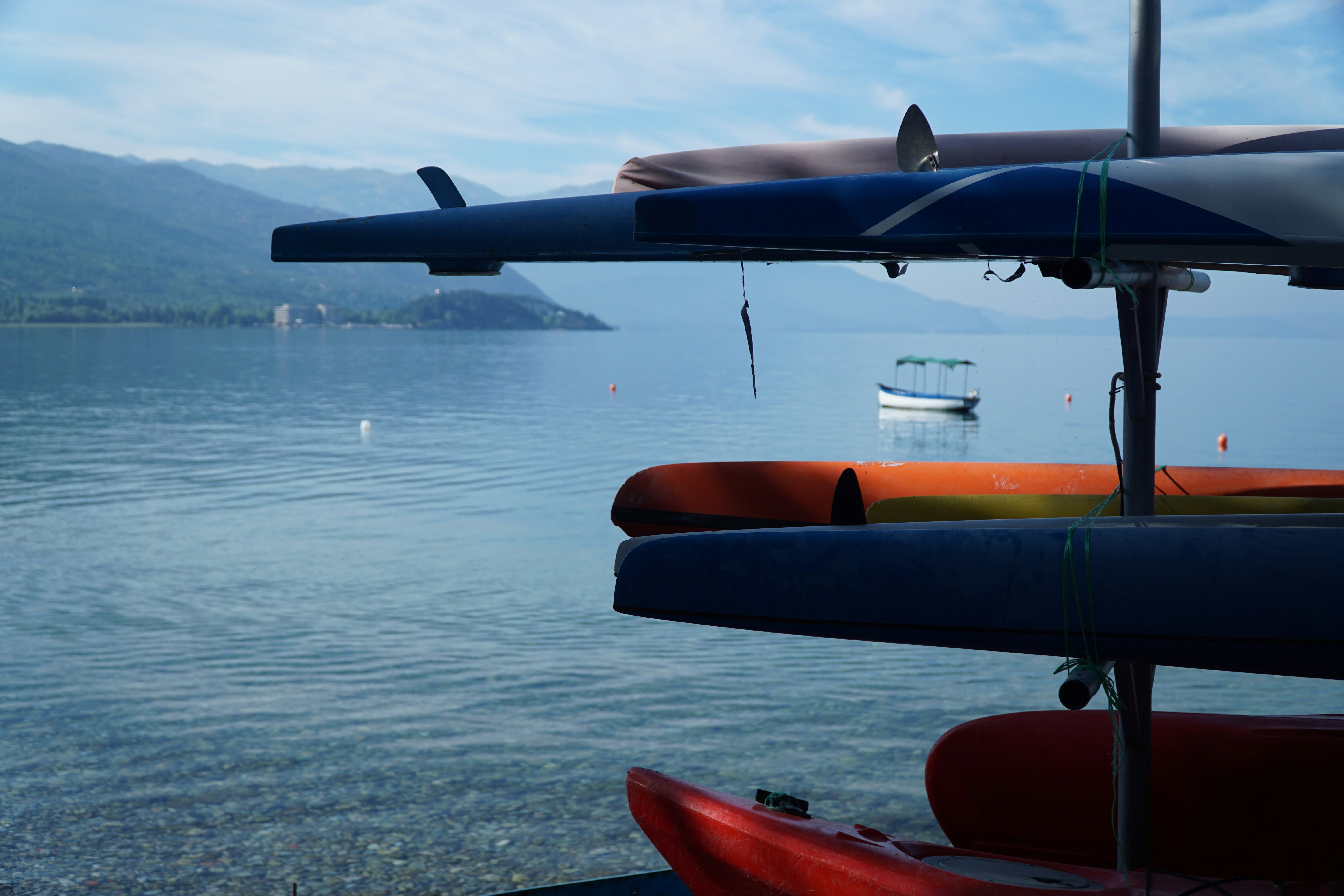 Kajaks stapeln sich in der Nähe eines ruhigen blauen Sees