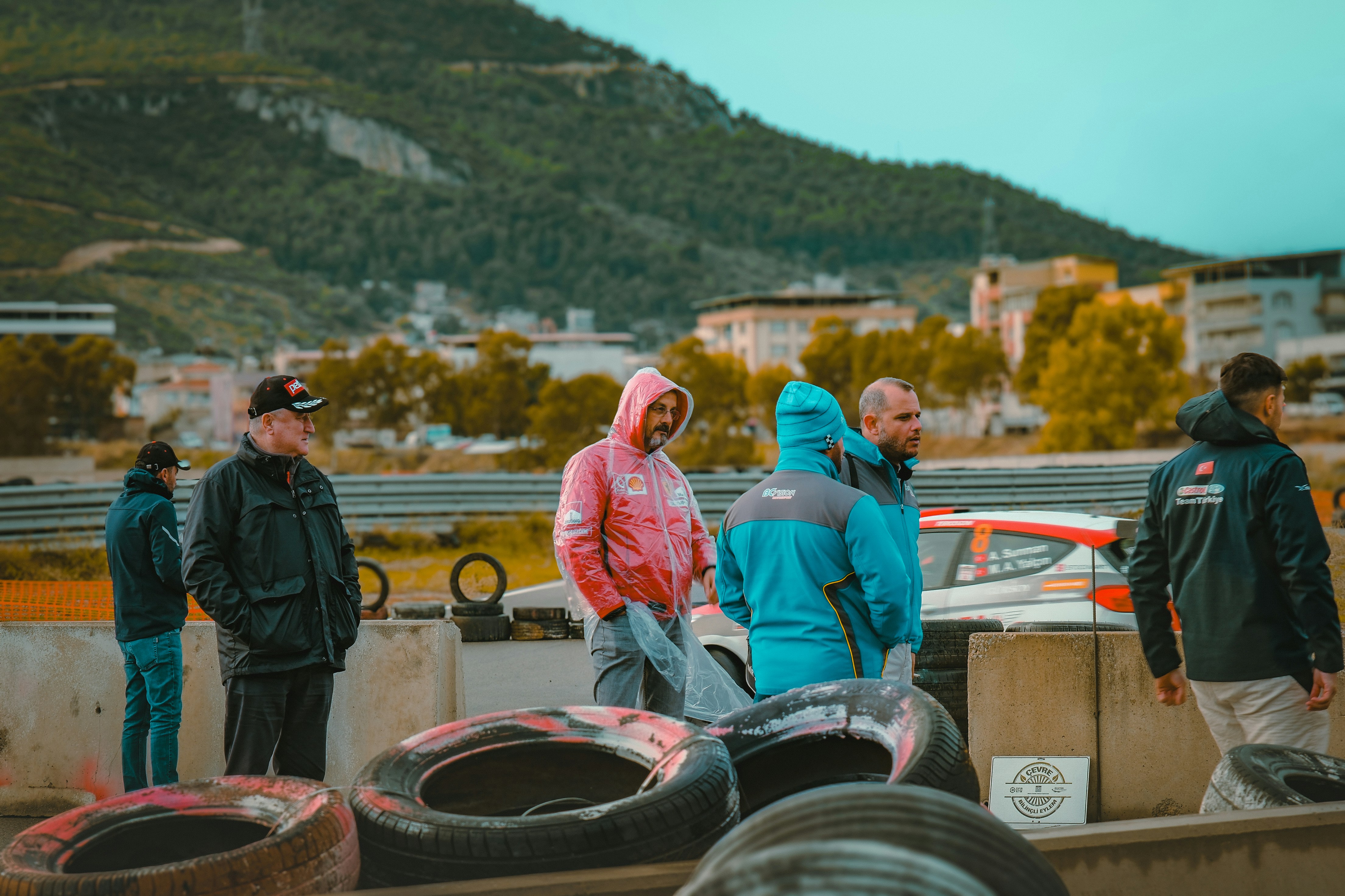 People standing near a race track with tires