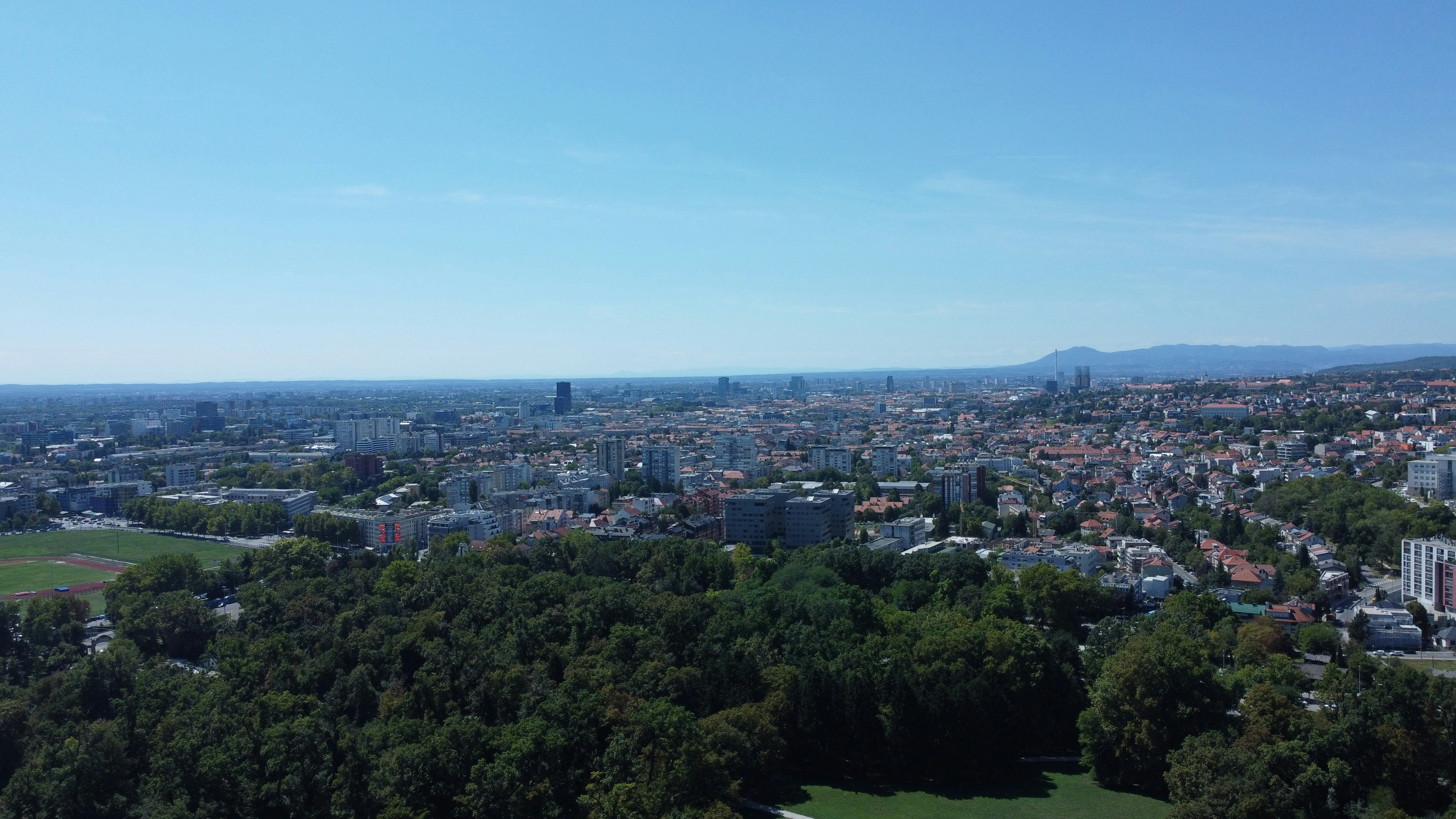 Aerial view of a sprawling cityscape with green parkland