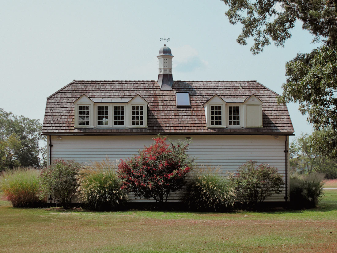 Temporary stock photograph of a small barn, garden, and mature trees; not the Ssussdriad Farm Campus.
