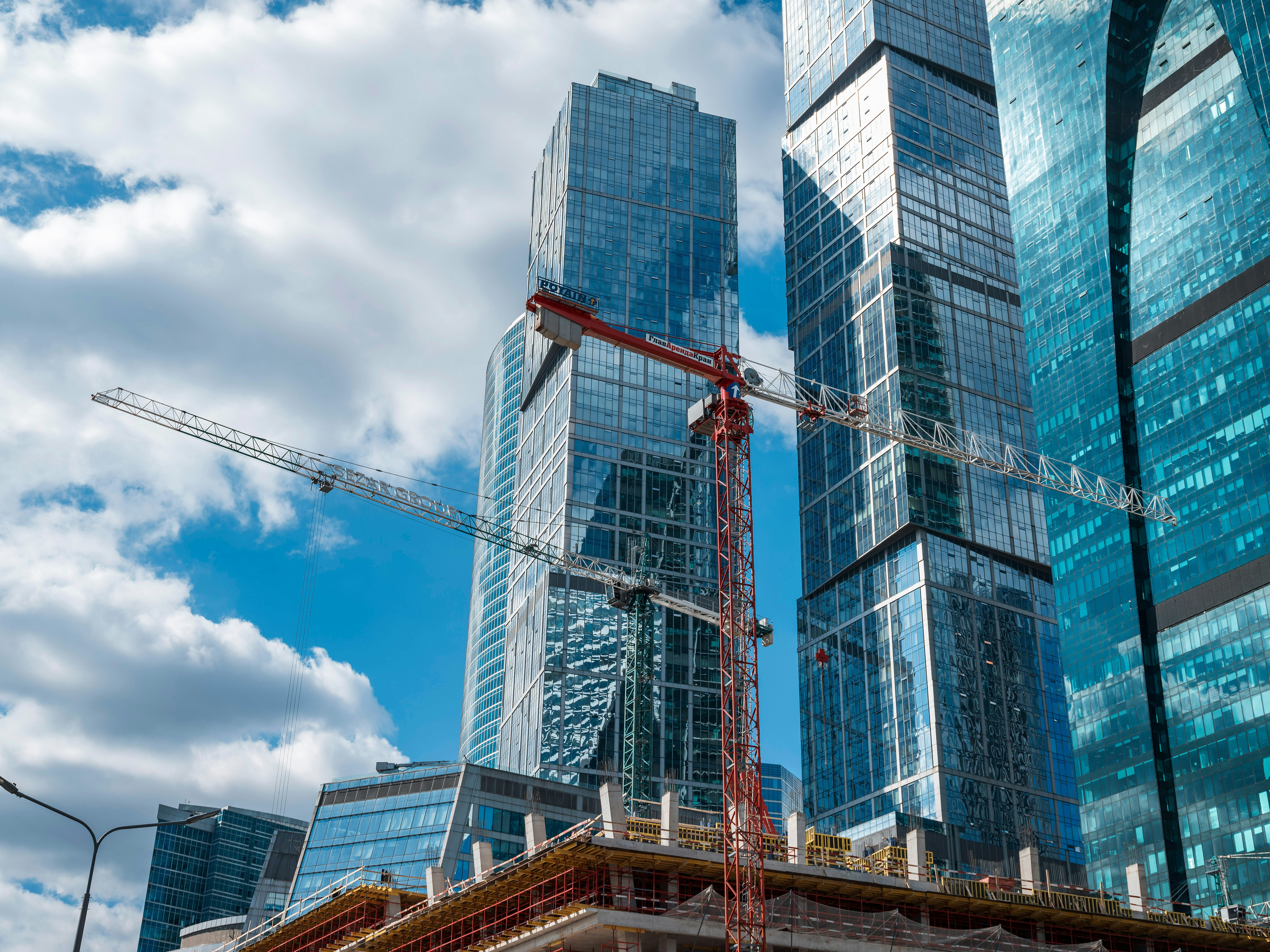 Modern skyscrapers under construction with cranes.