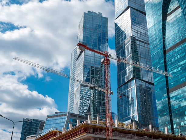 Modern skyscrapers under construction with cranes.