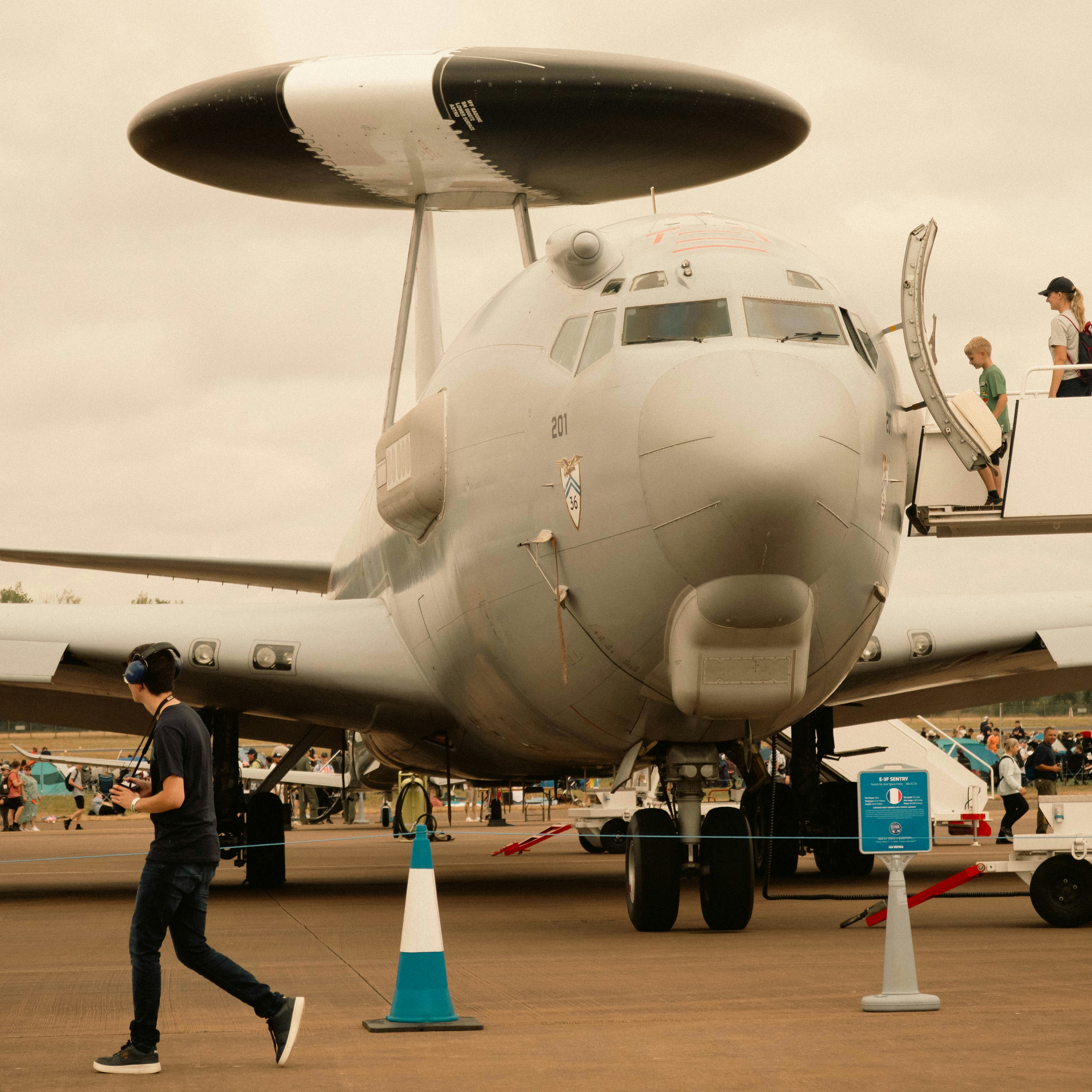 Large radar aircraft on tarmac with people nearby
