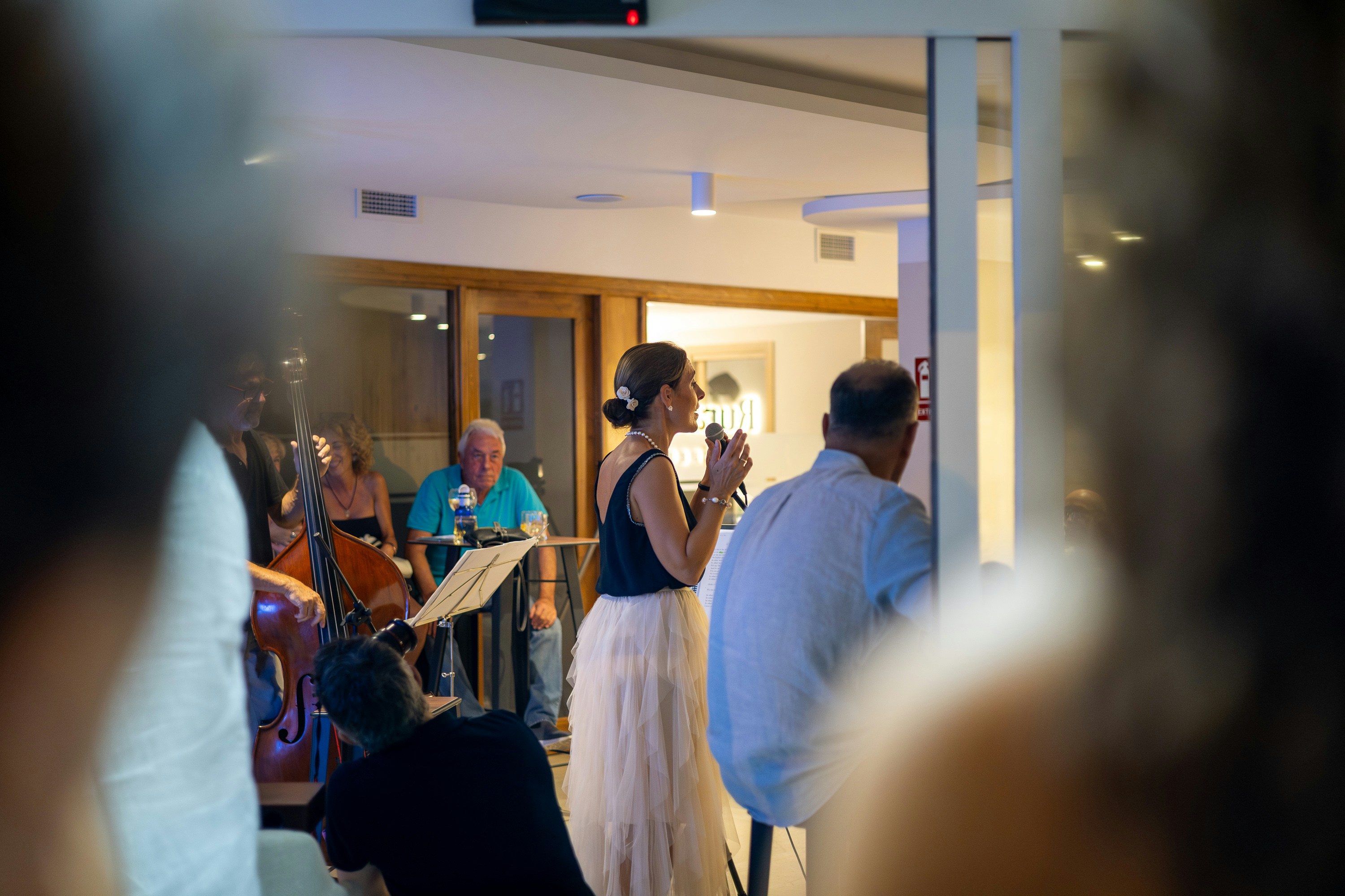 A woman sings on stage with a band performing.