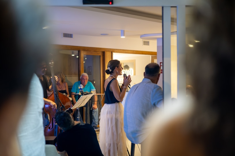 A woman sings on stage with a band performing.