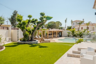 Luxurious backyard with pool, lounge chairs, and pergola.