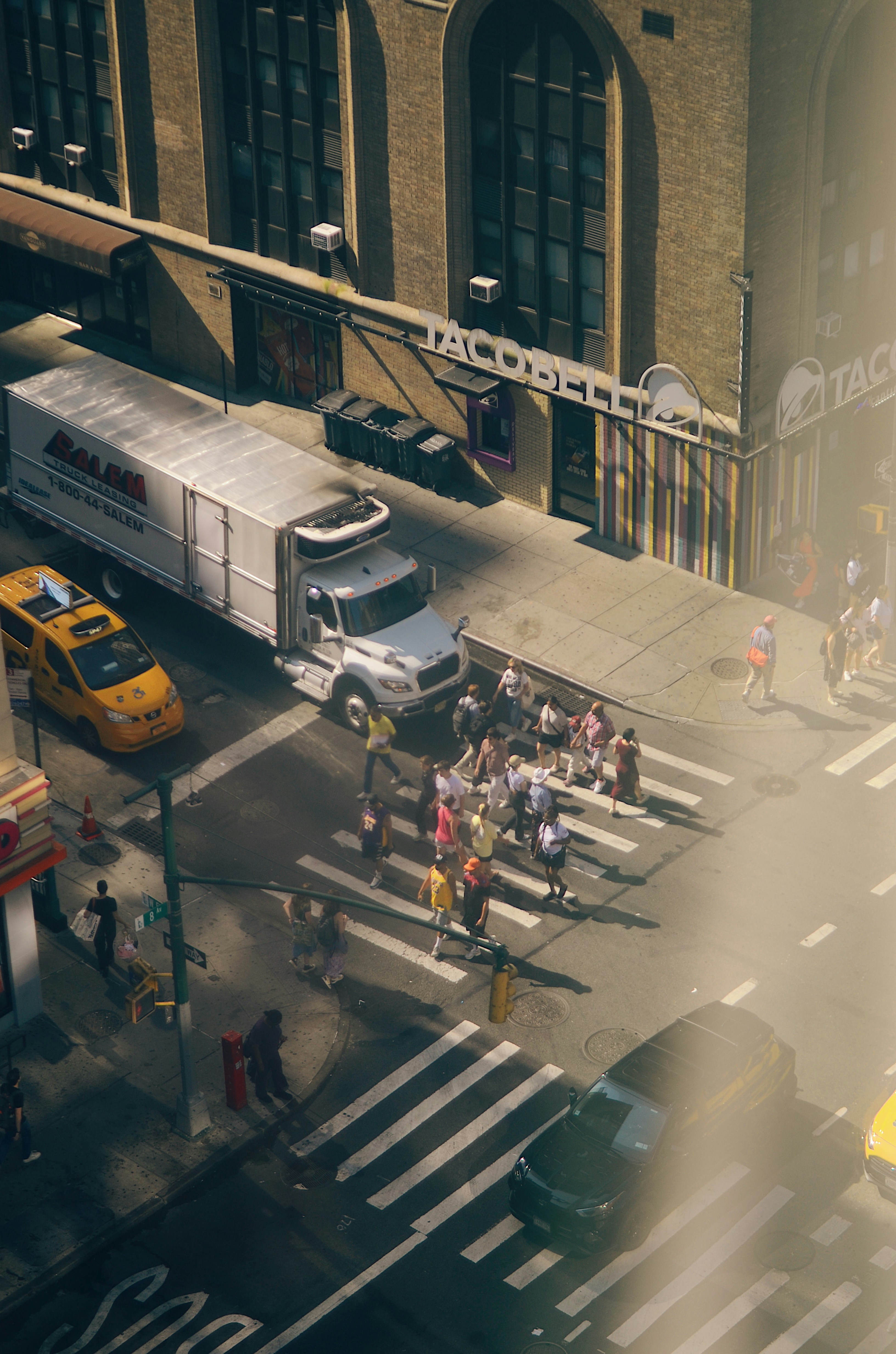 Menschen überqueren die Straße mit Taco-Glocke und Lastwagen