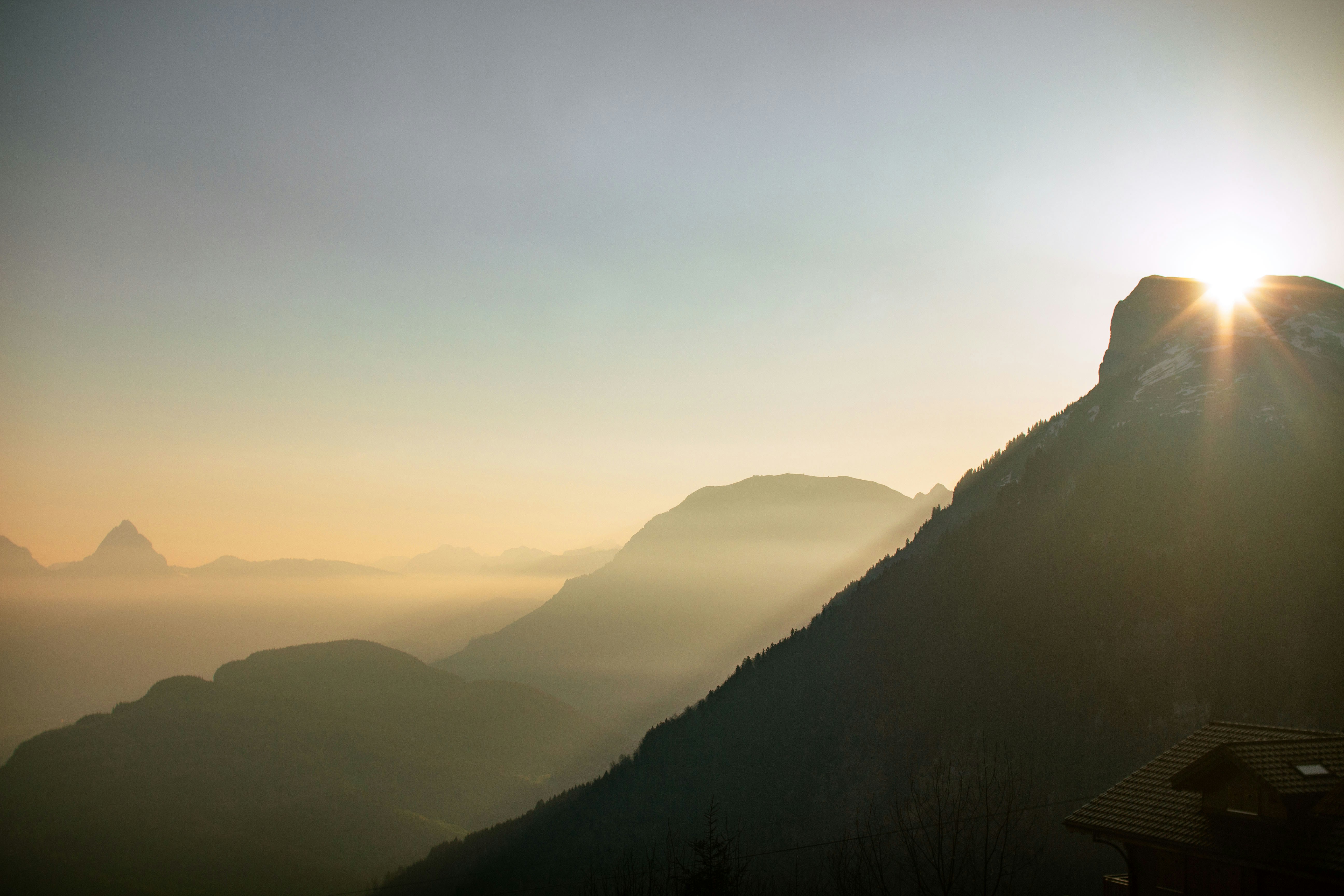 Sun setting behind a mountain peak
