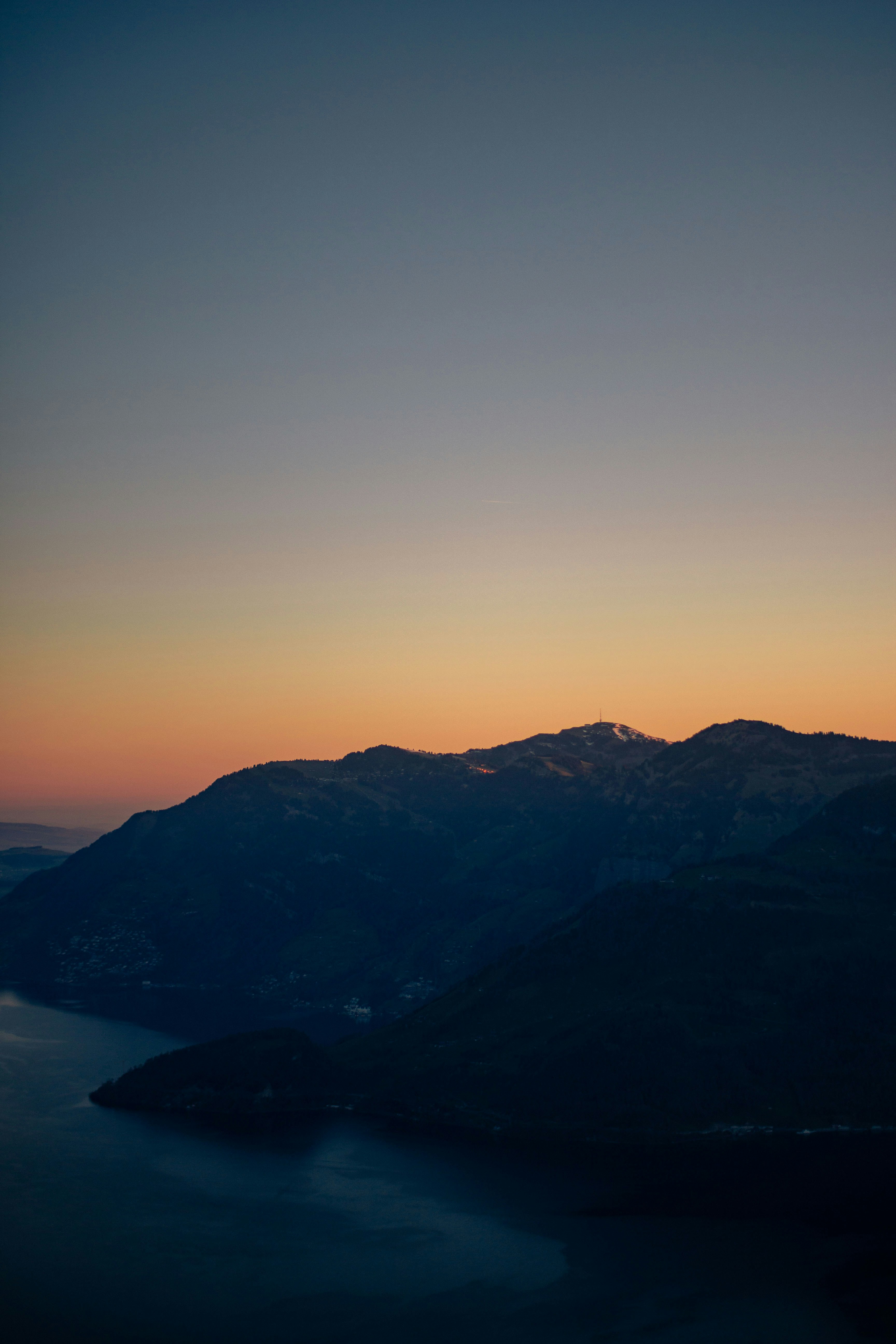 Dark mountains by the water at sunset
