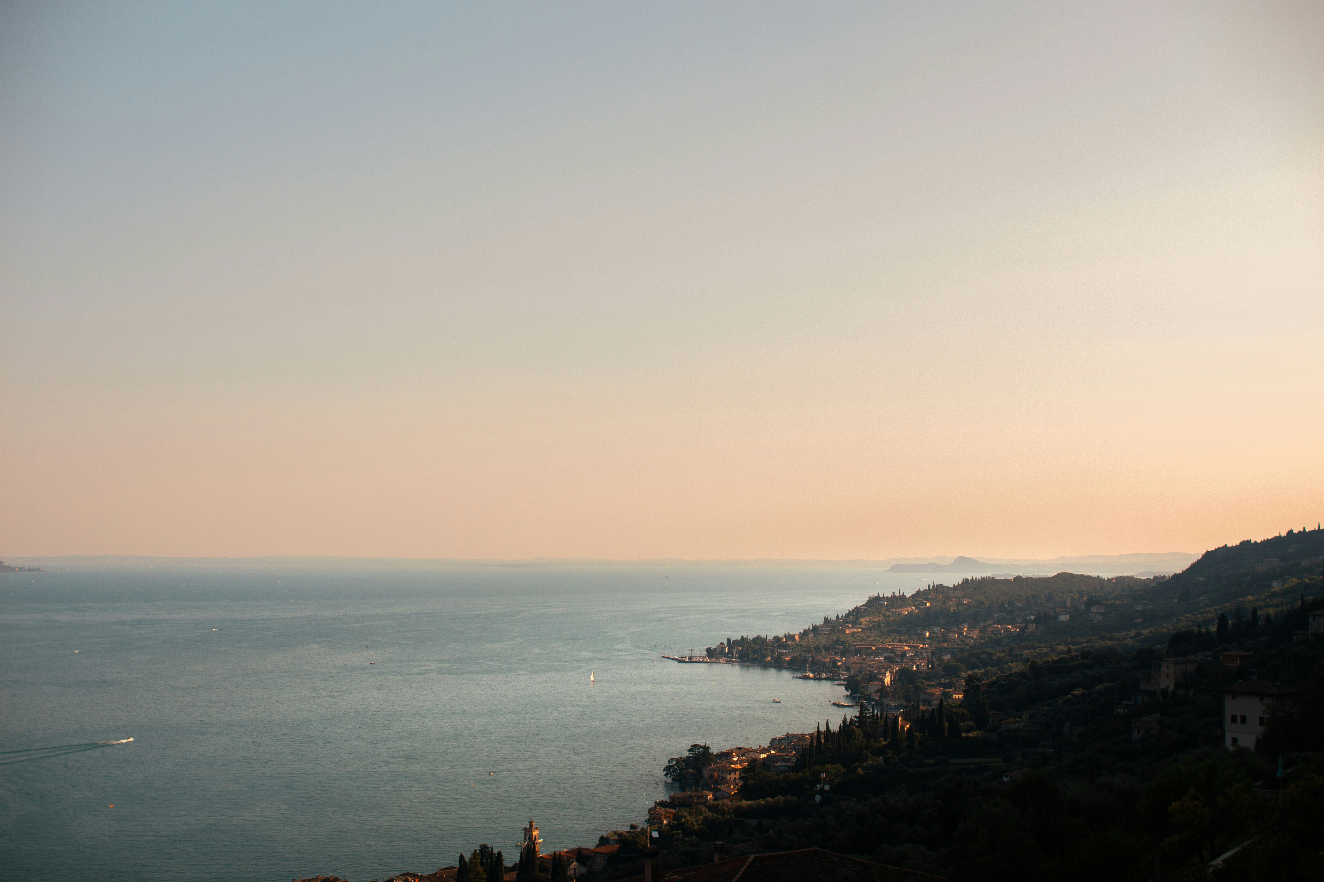 Coastal town nestled along a calm sea at sunset.