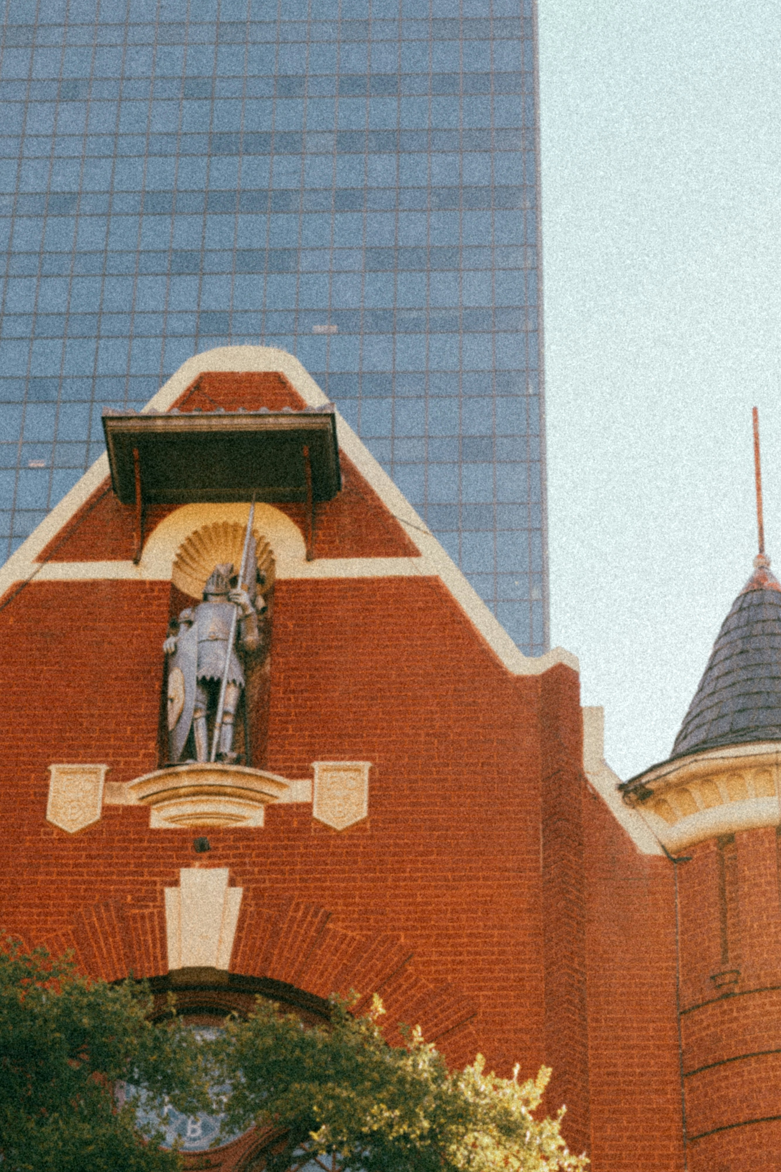 Estátua na construção de tijolos vermelhos com arranha-céu moderno atrás