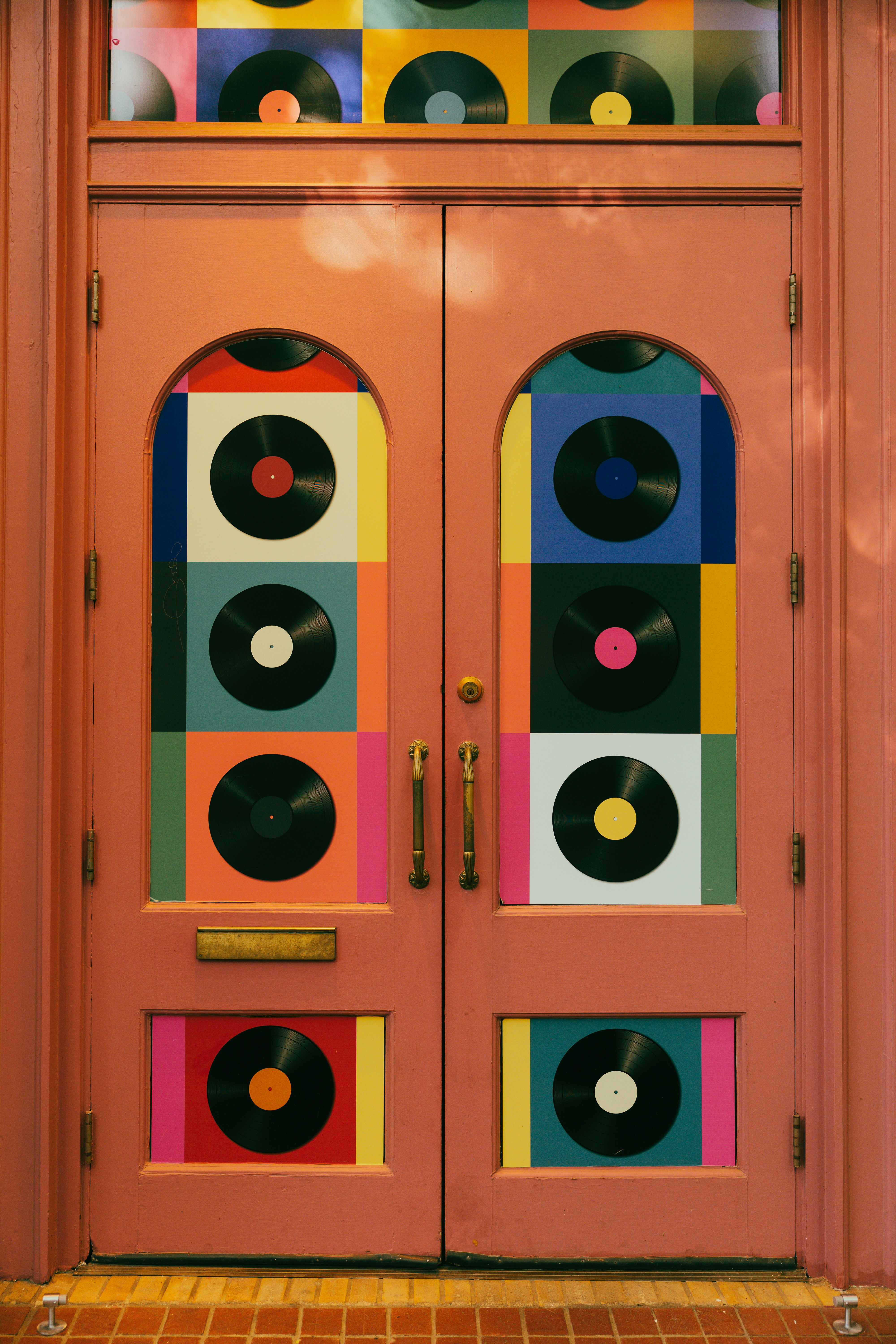 Portas duplas cor-de-rosa decoradas com discos de vinil coloridos