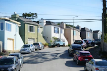 Cars parked on a residential street with houses.