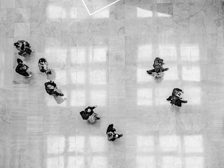 Several people walk across a tiled floor.
