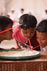 Children playing a game with straws and flour