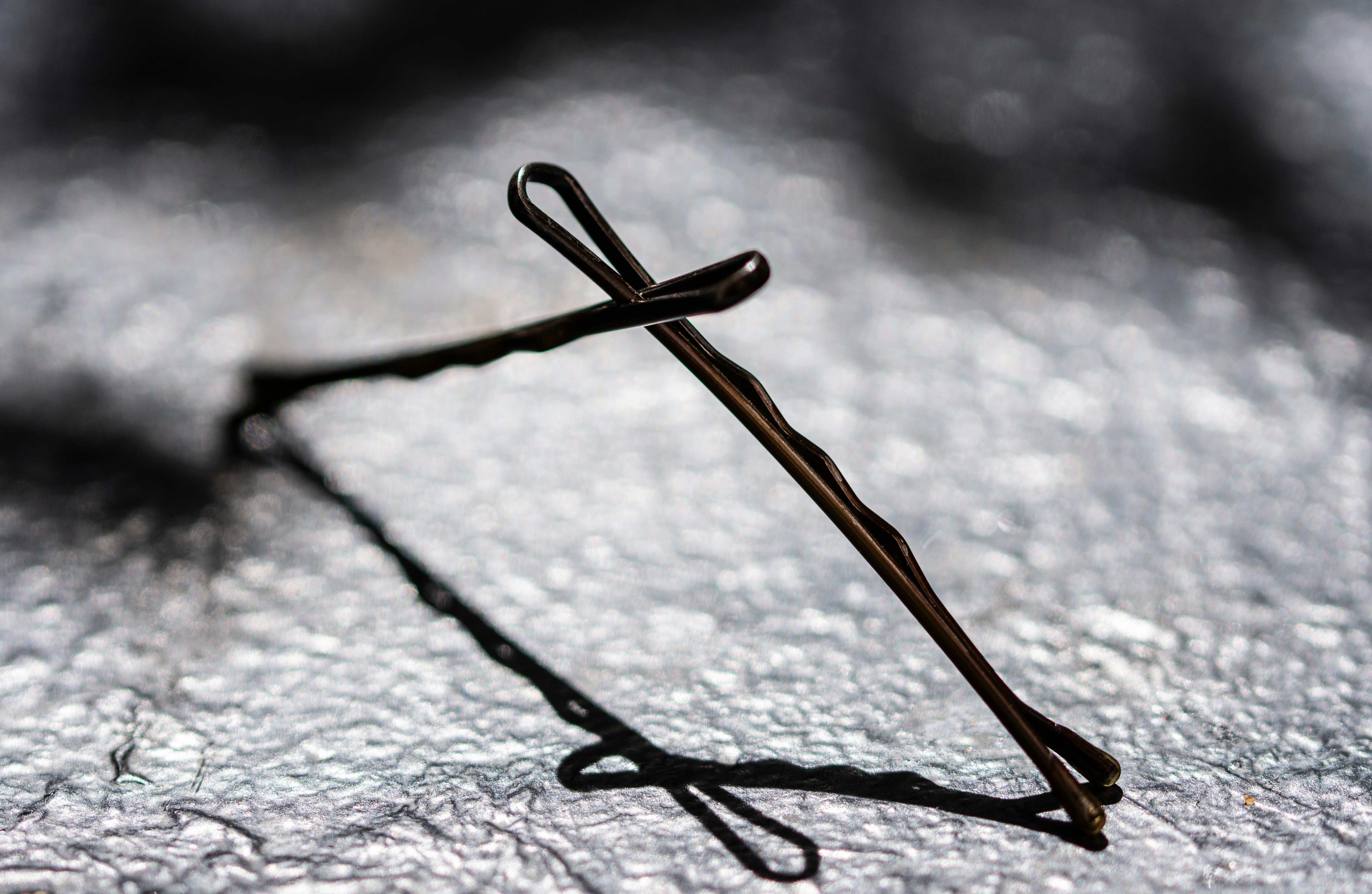 Two bobby pins resting on a textured surface