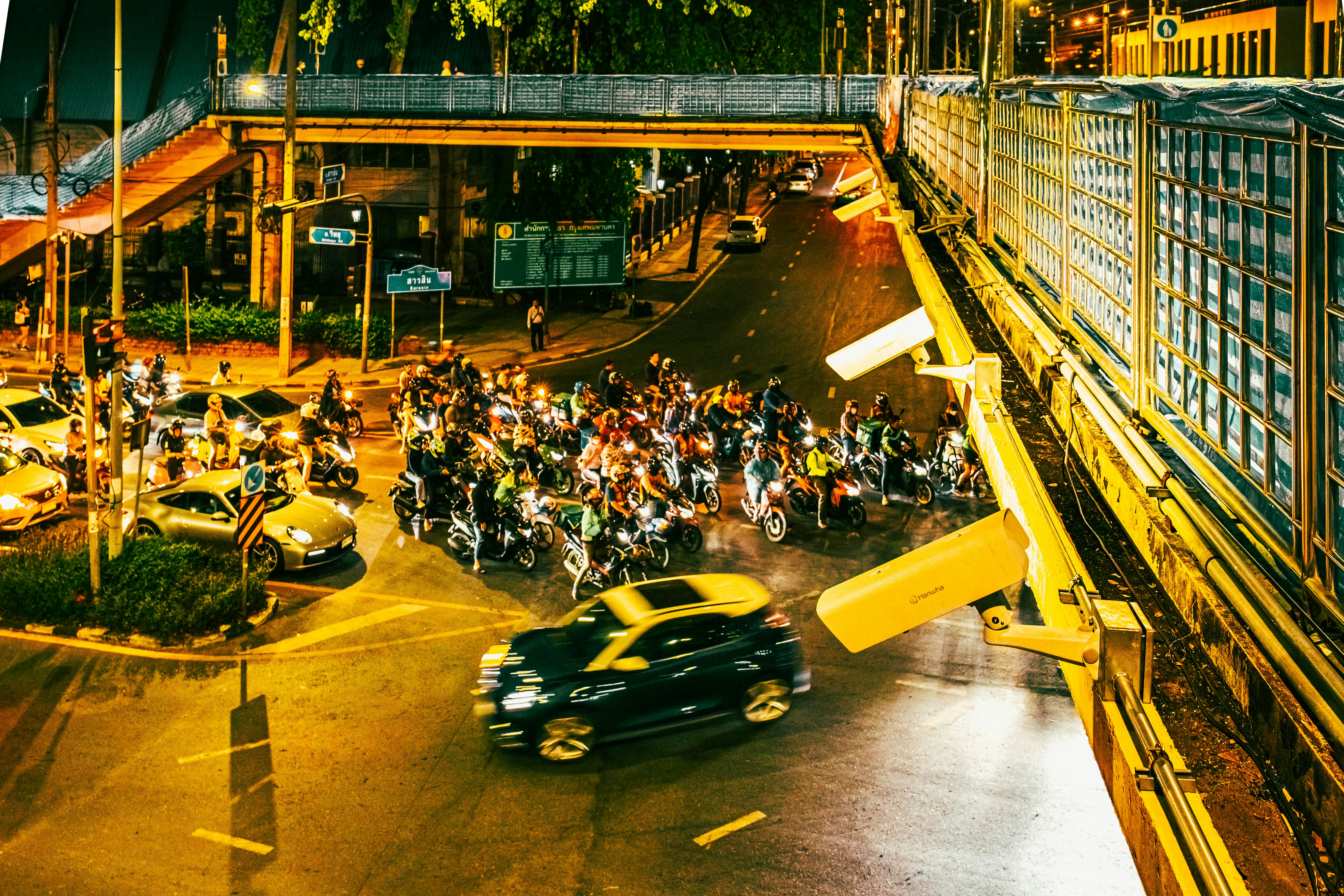 Busy intersection with cars and motorcycles at night